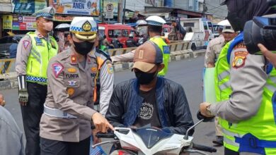 Kasat Lantas Polres Metro Jakarta Selatan Kompol Yunita Rungkat saat mengecek surat-surat berkendara seorang pengendara motor yang tak menggunakan helm di persimpangan Pasar Minggu, Jakarta Selatan.